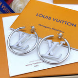 Silver hoop earrings with Louis Vuitton logo on a Louis Vuitton packaging